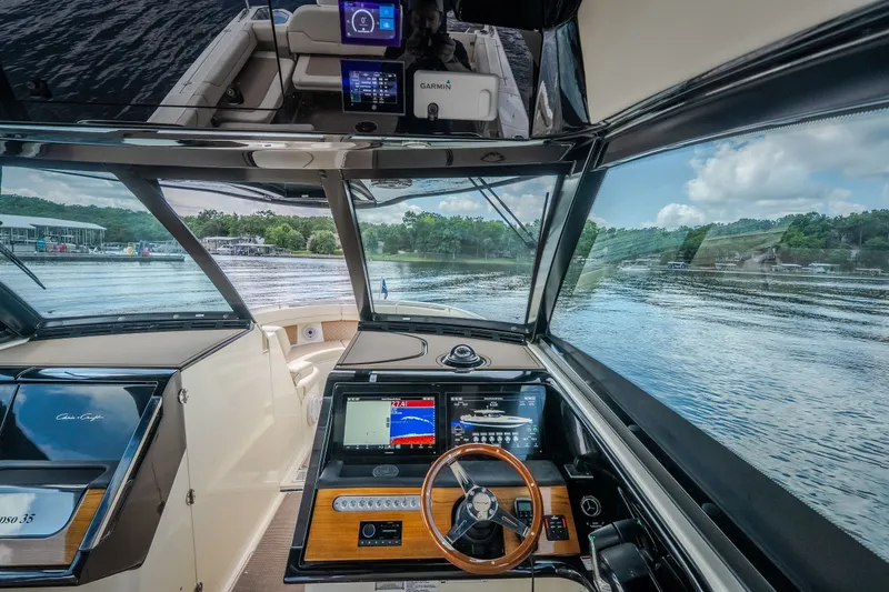 Slide: The Image of 2024 Chris-Craft Calypso 35 helm with advanced navigation system and scenic water view. - 30