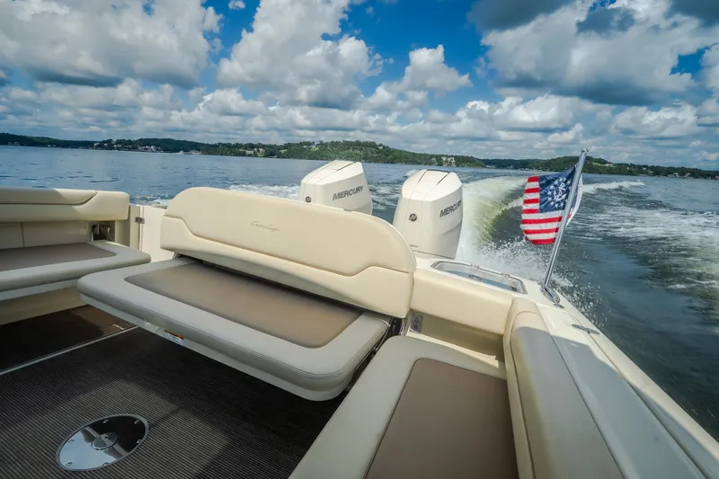Slide: The Image of 2024 Chris-Craft Calypso 35 cruising on a lake with American flag and twin Mercury engines. - 60