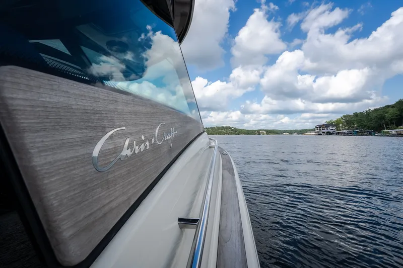 Slide: The Image of 2024 Chris-Craft Calypso 35 boat on a serene lake under a blue sky. - 9