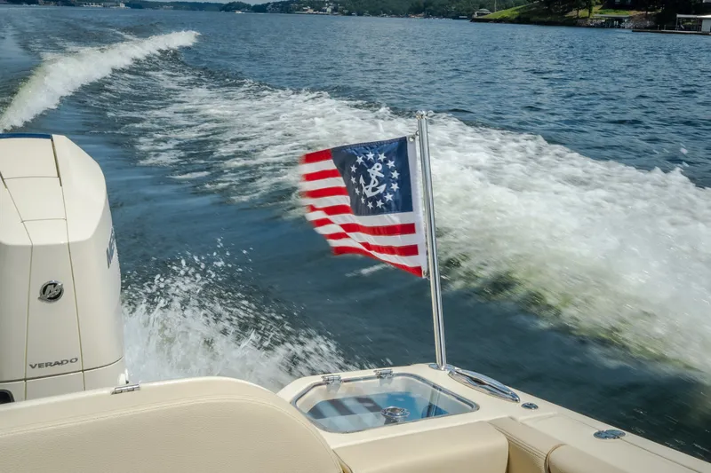 Slide: The Image of 2024 Chris-Craft Calypso 35 cruising on a lake with American flag waving. - 59