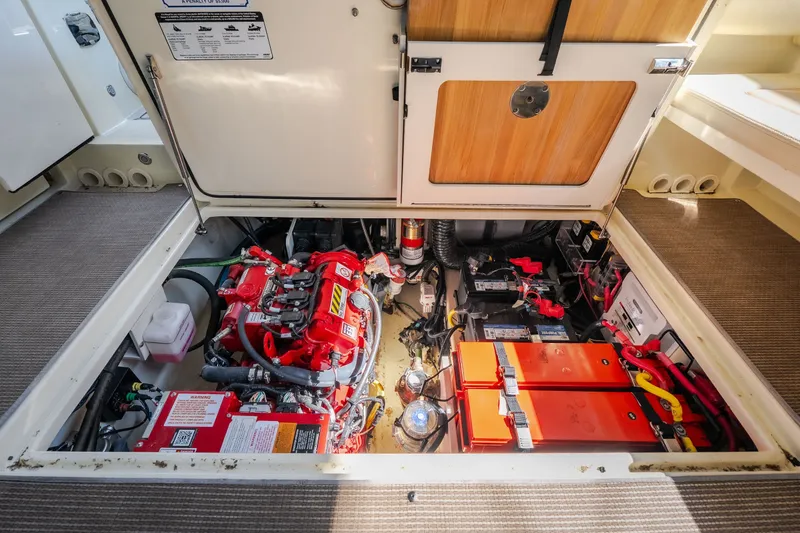 Slide: The Image of Engine compartment of 2024 Chris-Craft Calypso 35, showcasing batteries and mechanical components. - 57