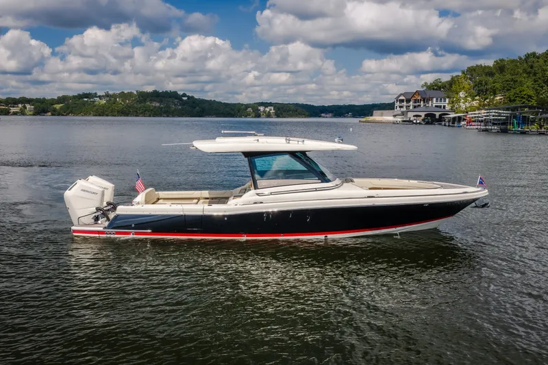 Slide: The Image of 2024 Chris-Craft Calypso 35 boat on a serene lake with scenic background. - 18