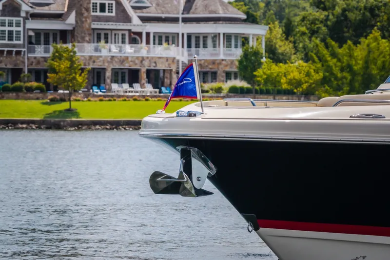 Slide: The Image of 2024 Chris-Craft Calypso 35 boat docked near a luxurious waterfront home. - 6