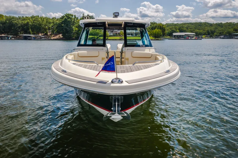 Slide: The Image of 2024 Chris-Craft Calypso 35 boat on a serene lake with lush greenery. - 5