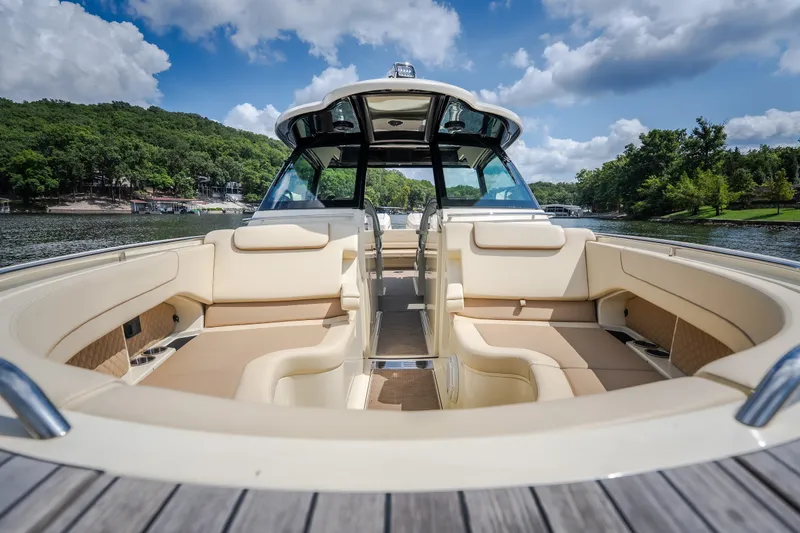 Slide: The Image of 2024 Chris-Craft Calypso 35 boat interior with luxurious seating on a scenic lake. - 52