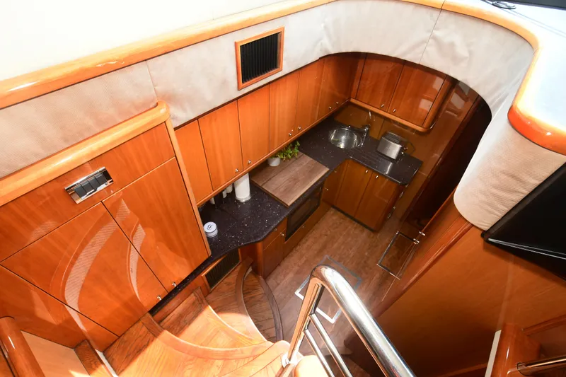 Slide: The Image of 2006 Sunseeker Manhattan 50 yacht interior with wooden cabinetry and modern kitchen amenities. - 18