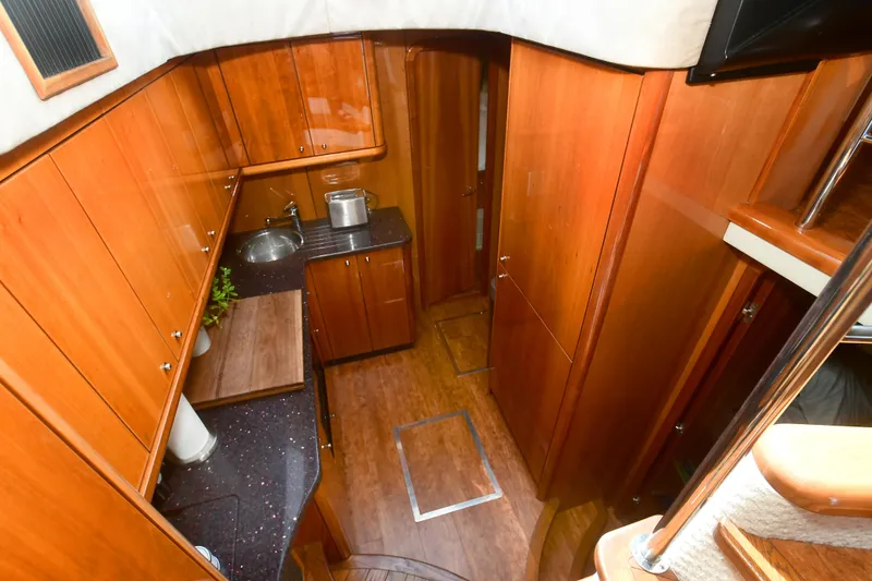 Slide: The Image of Interior of 2006 Sunseeker Manhattan 50 yacht, featuring a compact wooden kitchen area. - 19