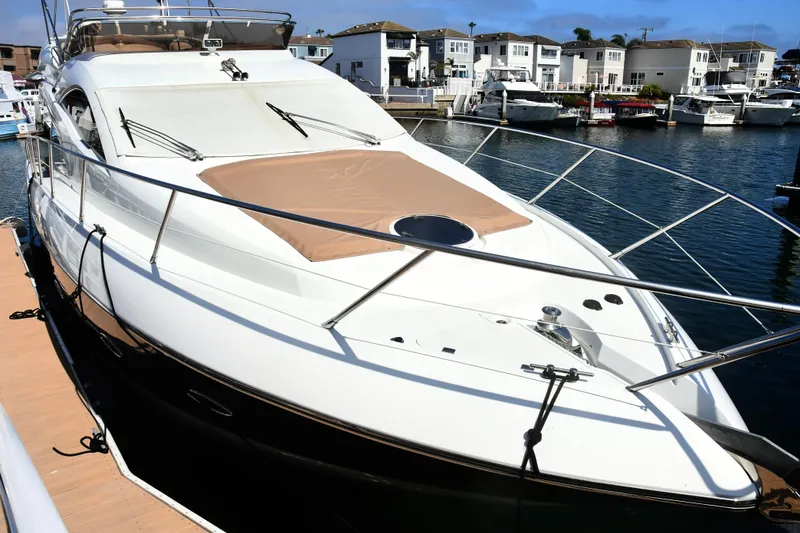 Slide: The Image of 2006 Sunseeker Manhattan 50 yacht docked in a marina, showcasing sleek design and luxury features. - 2