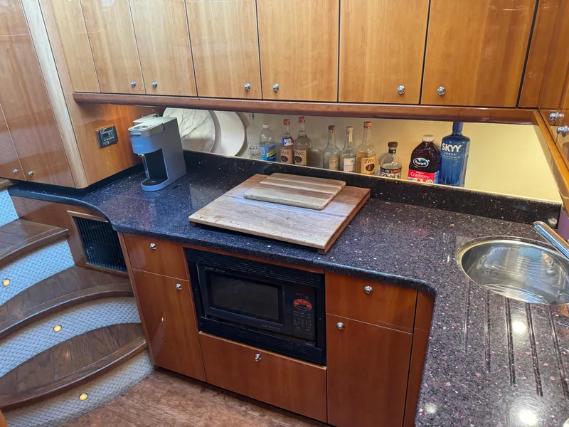 Slide: The Image of Luxurious 2006 Sunseeker Manhattan 50 yacht kitchen with modern amenities and elegant wood cabinetry. - 20