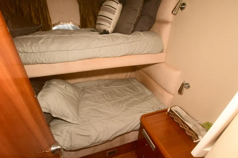 Slide: The Image of Bunk beds in 2006 Sunseeker Manhattan 50 yacht cabin, featuring cozy bedding and wooden accents. - 26