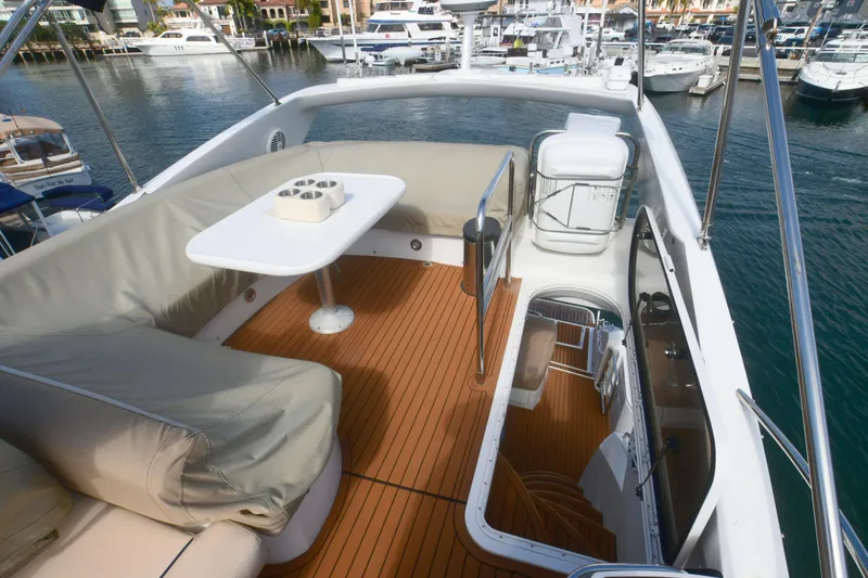 Slide: The Image of Flybridge of 2006 Sunseeker Manhattan 50 yacht with seating and table, docked in marina. - 41
