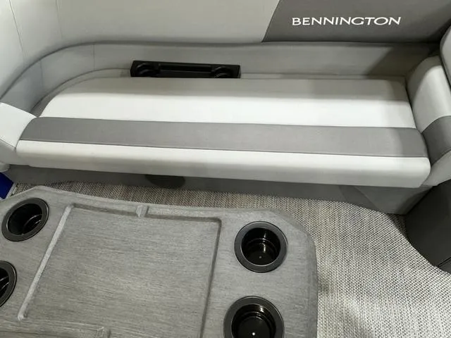 Slide: The Image of 2024 Bennington 20 SVSR pontoon boat in a warehouse, covered with a blue tarp. - 14