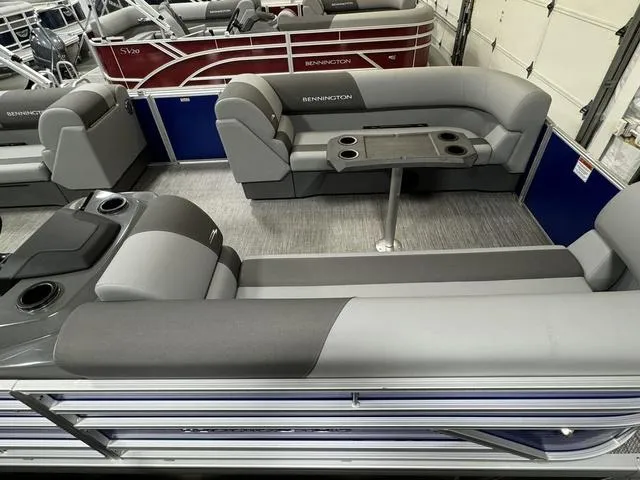 Slide: The Image of 2024 Bennington 20 SVSR pontoon boat in a warehouse, covered with a blue tarp. - 15