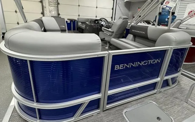 Slide: The Image of 2024 Bennington 20 SVSR pontoon boat with blue and gray seating in showroom. - 19