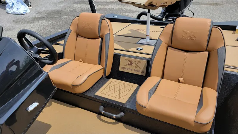 Slide: The Image of 2025 Xpress H20C Crappie boat interior with tan seats and steering wheel. - 13