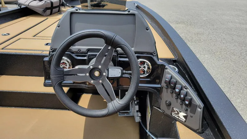 Slide: The Image of 2025 Xpress H20C Crappie boat dashboard with steering wheel and control panel. - 14