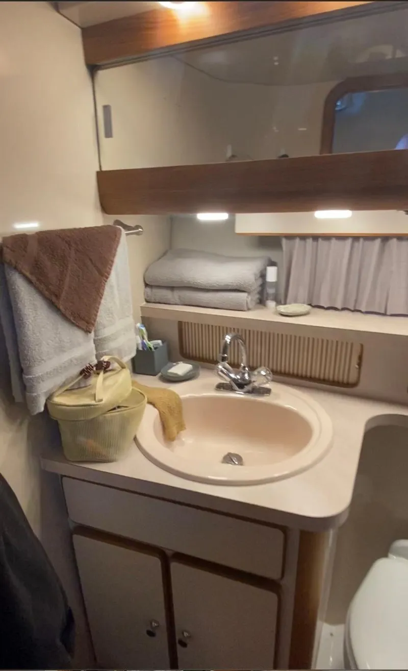 Slide: The Image of 1992 Regal Commodore 400 bathroom with sink, mirror, and storage cabinets. - 12