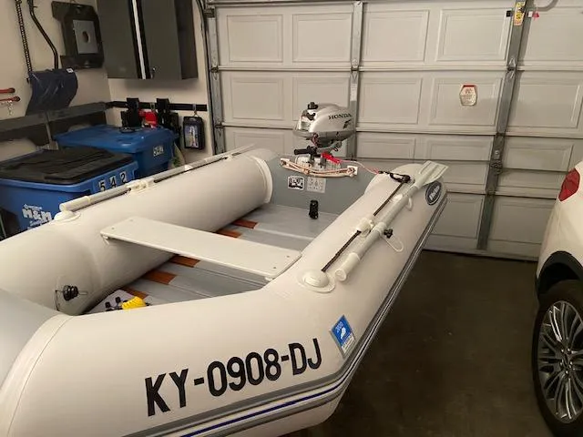Slide: The Image of 1992 Regal Commodore 400 inflatable boat with Honda outboard motor in a garage. - 22