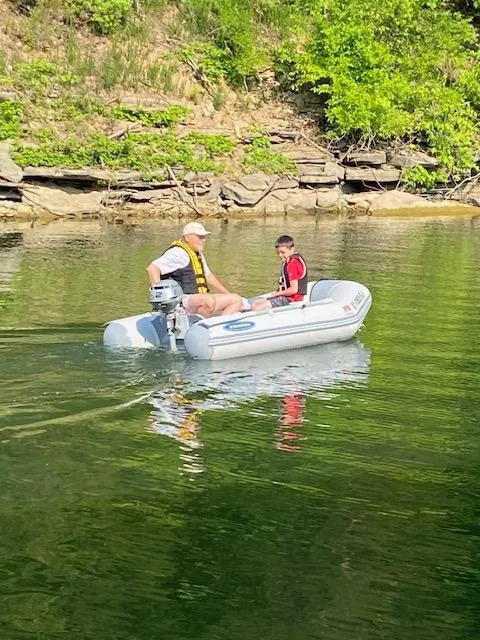 Slide: The Image of Man and child boating on a 1992 Regal Commodore 400 in a serene lake. - 23