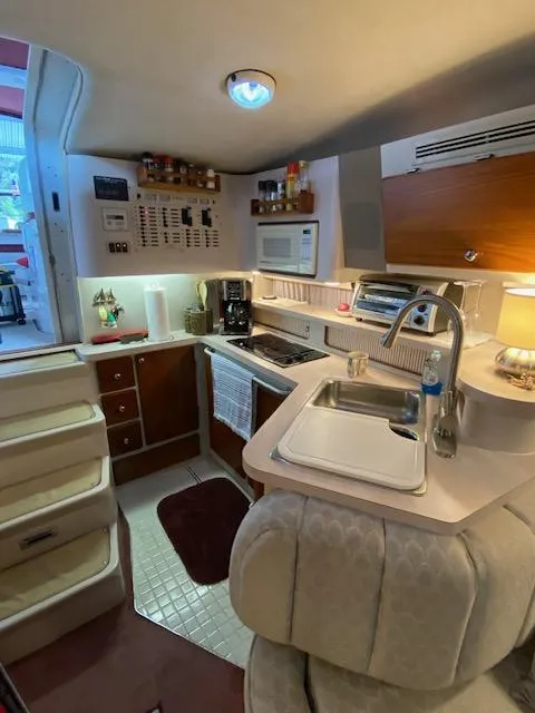 Slide: The Image of 1992 Regal Commodore 400 boat interior kitchen with sink, stove, and microwave. - 5