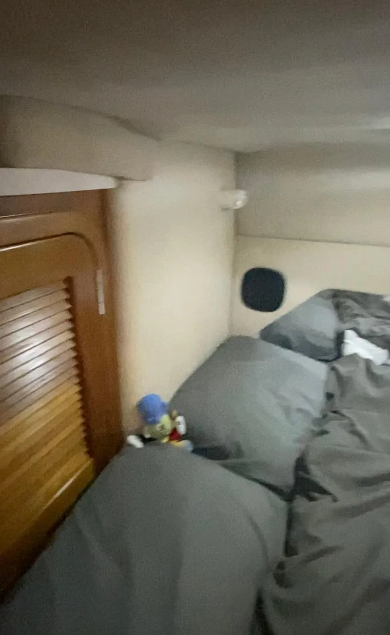 Slide: The Image of Interior cabin of a 1992 Regal Commodore 400 boat with bed and wooden door. - 9