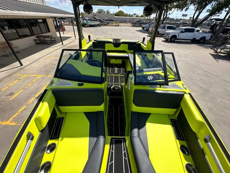 Slide: The Image of 2024 ATX Surf Boats 22 Type-S with vibrant lime green interior, docked outdoors. - 24