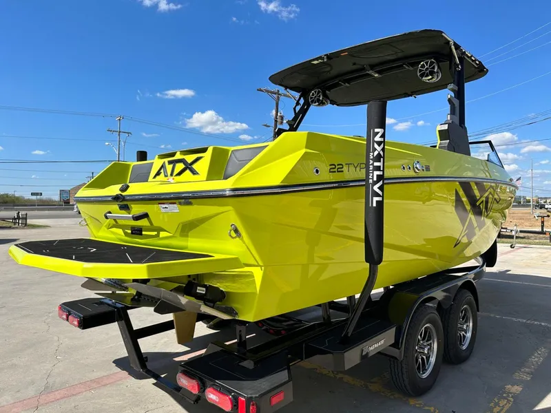 Slide: The Image of 2024 ATX Surf Boats 22 Type-S in vibrant yellow on a trailer, under a clear blue sky. - 4