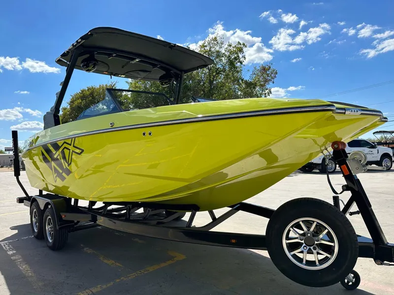 Slide: The Image of 2024 ATX Surf Boats 22 Type-S in vibrant yellow on a trailer under a clear blue sky. - 6