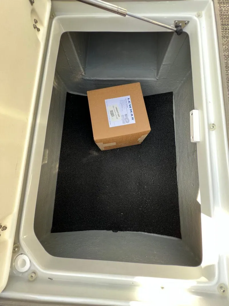 Slide: The Image of Storage compartment of 2024 Crownline 270 SS boat with a cardboard box inside. - 16