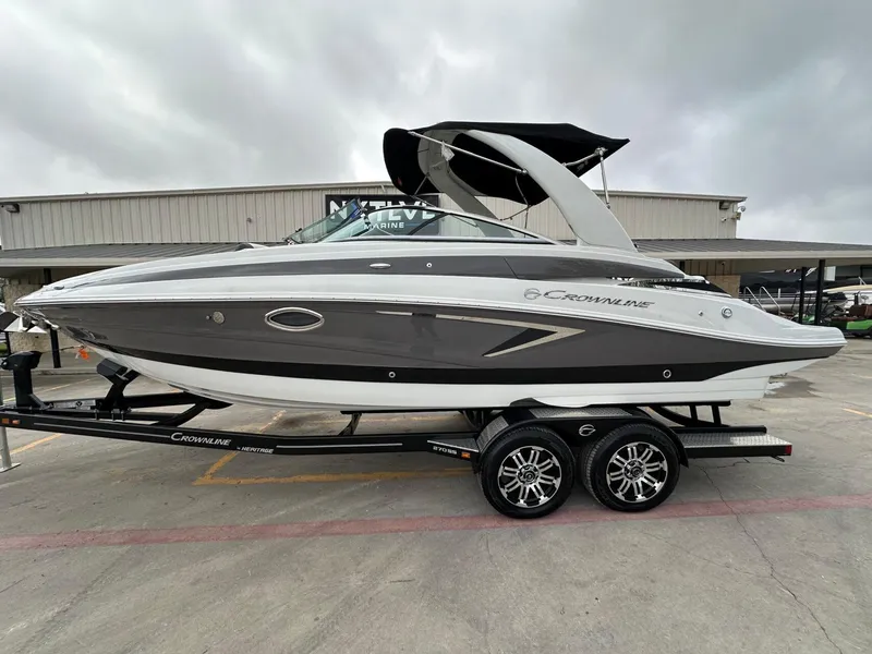 Slide: The Image of 2024 Crownline 270 SS boat on trailer, gray and white design, parked outdoors. - 17