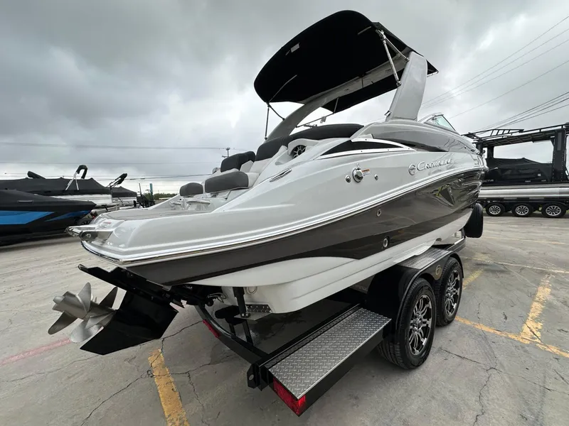Slide: The Image of 2024 Crownline 270 SS boat on trailer, overcast sky, rear view. - 20