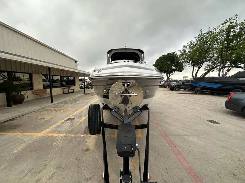 Slide: The Image of 2024 Crownline 270 SS boat on trailer in parking lot, overcast sky. - 23