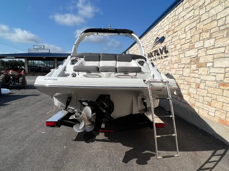 Slide: The Image of 2024 Crownline 270 SS boat with ladder, parked at NXT LVL Marine dealership. - 3