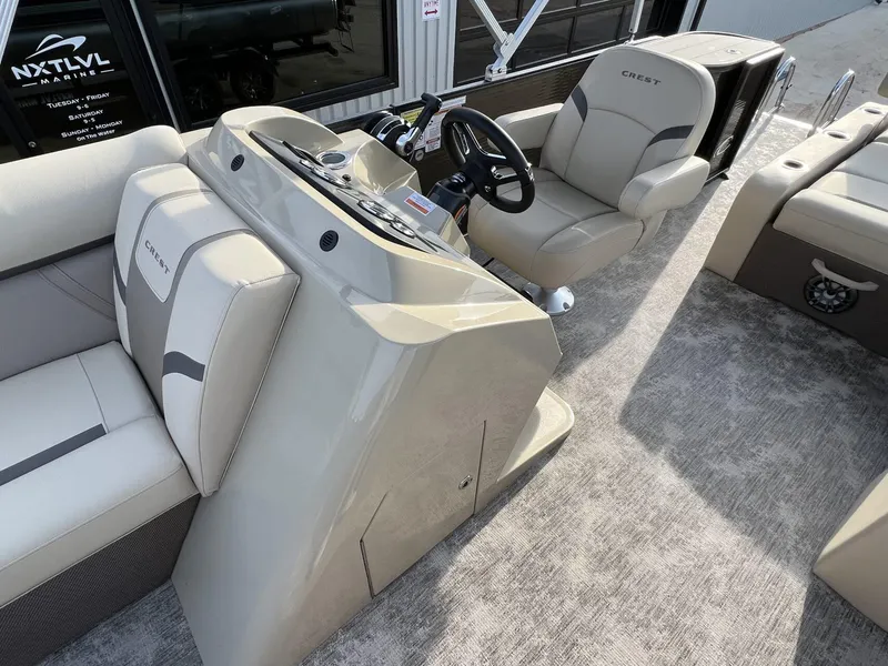 Slide: The Image of 2023 Crest Classic LX 220 SLS boat interior with beige seating and steering console. - 12