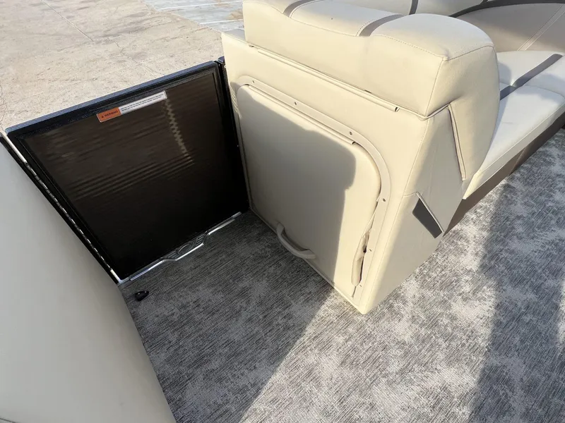 Slide: The Image of 2023 Crest Classic LX 220 SLS boat interior with beige seating and storage compartment. - 13