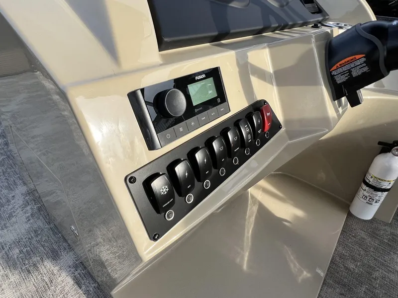 Slide: The Image of Control panel of 2023 Crest Classic LX 220 SLS boat with switches and stereo system. - 17