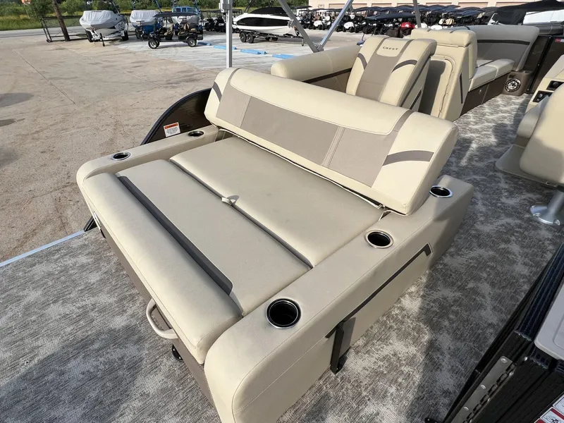 Slide: The Image of 2023 Crest Classic LX 220 SLS boat interior with beige seating and cup holders. - 21