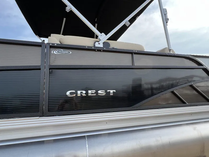 Slide: The Image of 2023 Crest Classic LX 220 SLS pontoon boat with sleek black exterior design. - 4