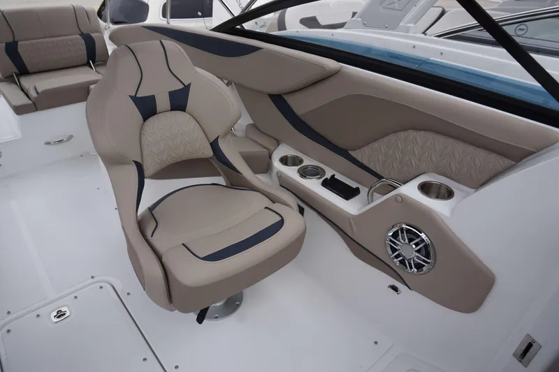 Slide: The Image of 2024 Hurricane 2600 SD boat interior with beige and navy seating, cup holders, and speaker. - 16