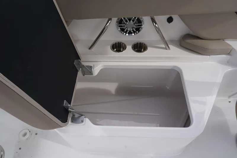 Slide: The Image of Open storage compartment in 2024 Hurricane 2600 SD boat with cup holders and speaker. - 8