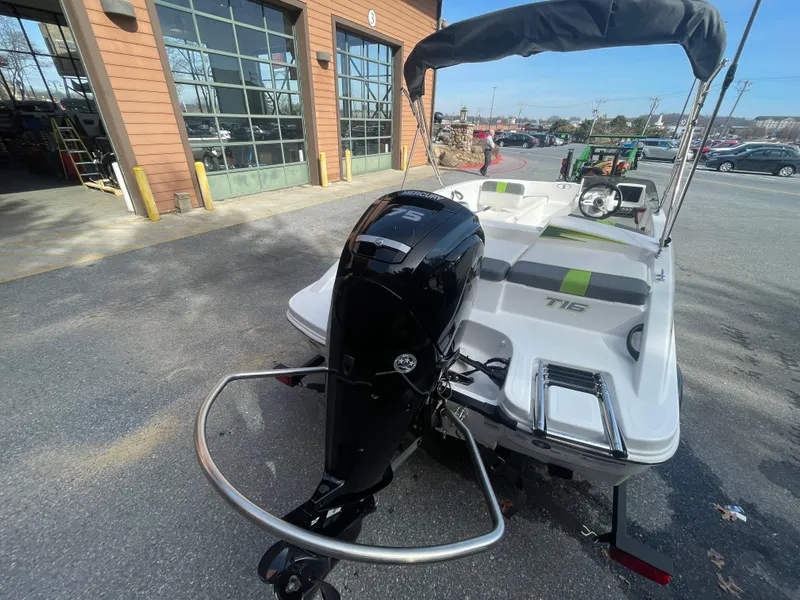 Slide: The Image of 2024 Tahoe T16 boat with outboard motor, parked outside a garage. - 4