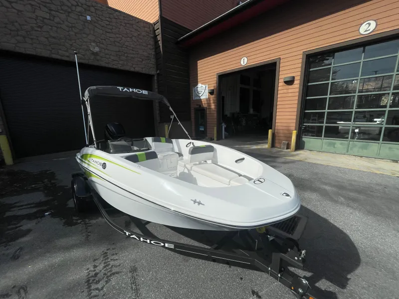 Slide: The Image of 2024 Tahoe T16 boat on trailer outside a garage. - 5