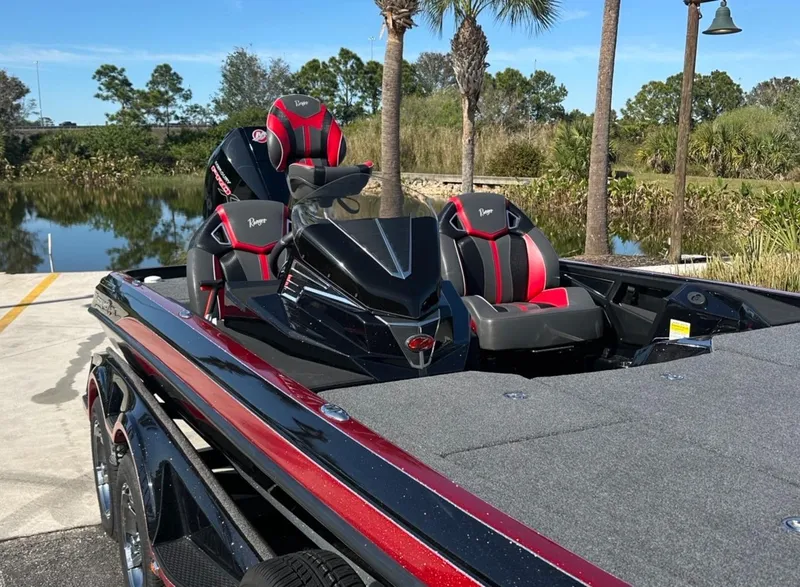 Slide: The Image of 2024 Ranger Z521R Ranger Cup boat with sleek design and red accents by a lake. - 7