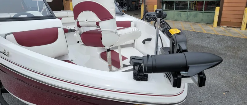 Slide: The Image of 2024 Tahoe 185 S boat with maroon and white seating, docked outdoors. - 2