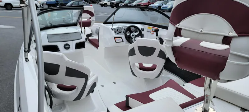 Slide: The Image of 2024 Tahoe 185 S boat interior with maroon and white seating, dashboard, and steering wheel. - 6