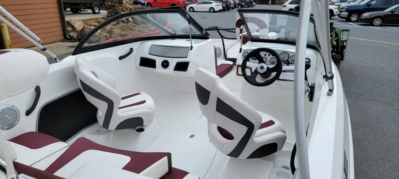 Slide: The Image of 2024 Tahoe 185 S boat interior with white and maroon seating, steering wheel, and dashboard. - 7
