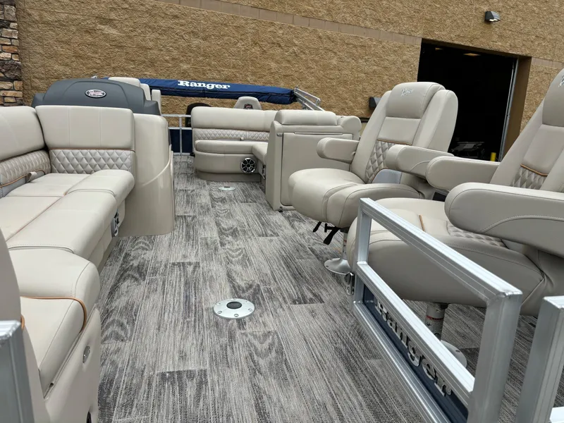 Slide: The Image of 2024 Ranger Reata 220FC pontoon boat interior with luxurious seating and wood-style flooring. - 3