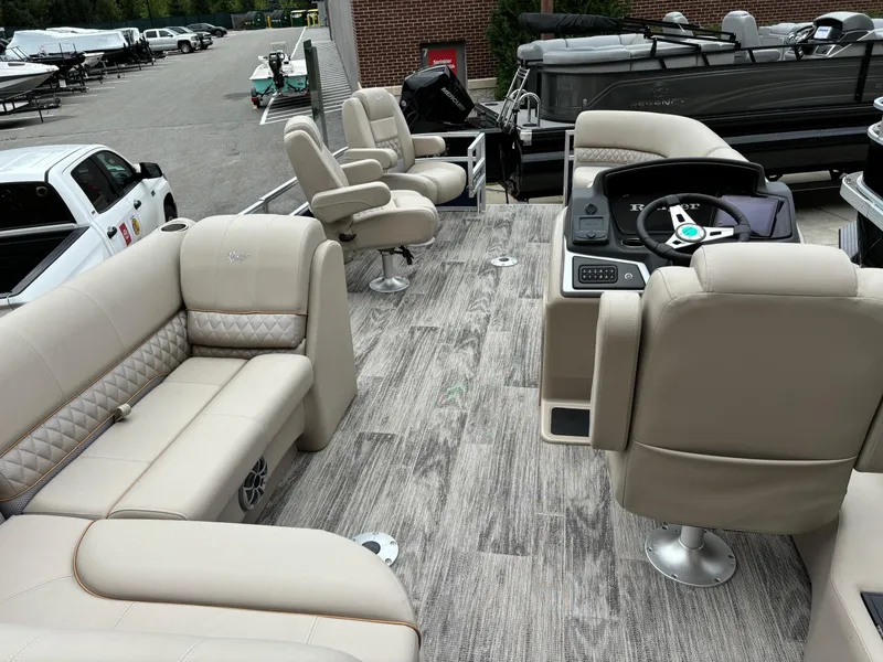Slide: The Image of 2024 Ranger Reata 220FC pontoon boat with beige seating and modern dashboard. - 4