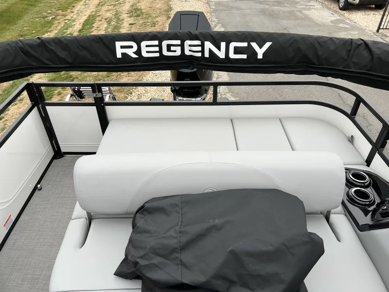 Slide: The Image of 2024 Regency 250 DL3 pontoon boat with cushioned seating and cup holders. - 11
