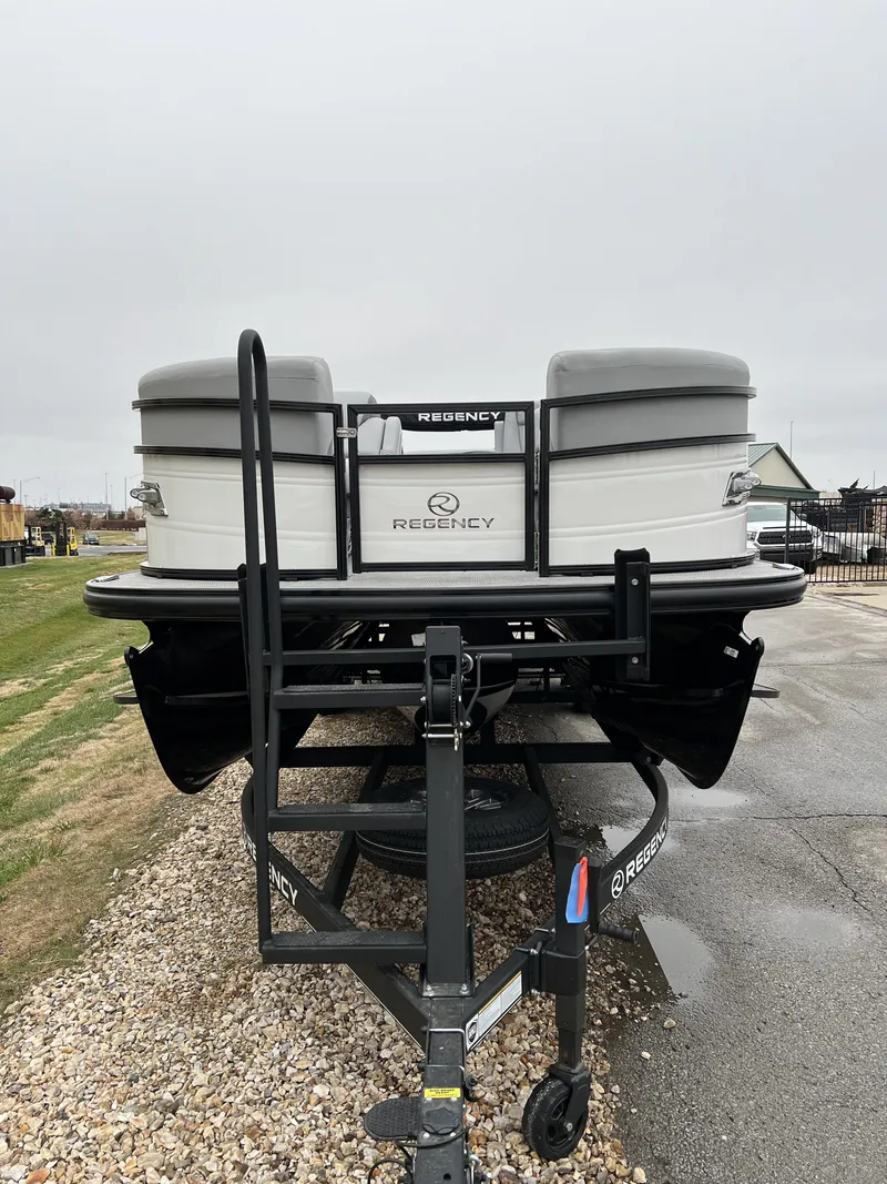 Slide: The Image of 2024 Regency 250 DL3 pontoon boat on a trailer. - 2